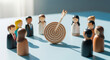 © Kaluya Stock - Wooden figurines representing a diverse team stand around a target with an arrow in the center, symbolizing business goals, collaboration, success, and strategy