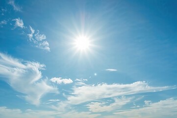 bright sun shining in a clear sky with soft clouds