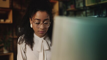 Focused African American businesswoman in vintage clothes working on computer