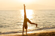© BGStock72 - Joyful beach handstand at sunset creates a moment of pure exhilaration
