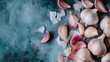 © Juan - Scattered garlic cloves on textured teal surface with soft daylight and rustic culinary background