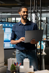 middle eastern engineer reviewing construction site measurements on laptop, ensuring the residential