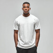 © Surachetsh - A Black man in a plain white t shirt stands against a neutral background. The blank shirt is ideal for clothing mockup and fashion display.