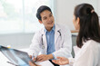 © amnaj - Two Asian doctors examining radiography in a bright medical office, collaborating on patient diagnosis and discussing treatment options