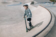 © Cavan Images - Young boy scooter at concrete skatepark