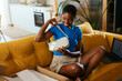 © Westend61 - Happy woman checking purse in living room at home