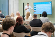 © Anton Gvozdikov - Professional speaker presents training session to audience in modern business seminar setting