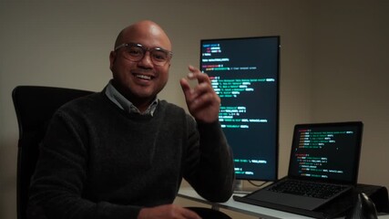 Male programmer wearing glasses works late at night with green code reflecting on his lenses, focusing on software development, coding, and cybersecurity analysis.
