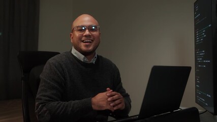 Side view male programmer wearing glasses works late at night with green code reflecting on his lenses, focusing on software development, coding, and cybersecurity analysis.