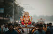 © Nobody - Minimalistic poster of devotees carrying a clay Ganesha idol during immersion procession,clean overlay typography reading ‘Happy Ananta Chaturdashi’