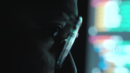 Close-up Reflection green code in lenses of glasses and eye of Male programmer works late at night, focusing on software development, coding, and cybersecurity analysis.