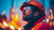 © sommersby - Close-up profile of focused industrial worker in orange hard hat and safety glasses, illuminated by warm and cool atmospheric bokeh lights