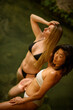 © Mariia Andreeva - Two young female models, Asian and blonde, in natural water outdoors under sunlight, highlighting racial and cultural diversity, natural beauty, serene lifestyle, and connection with nature.