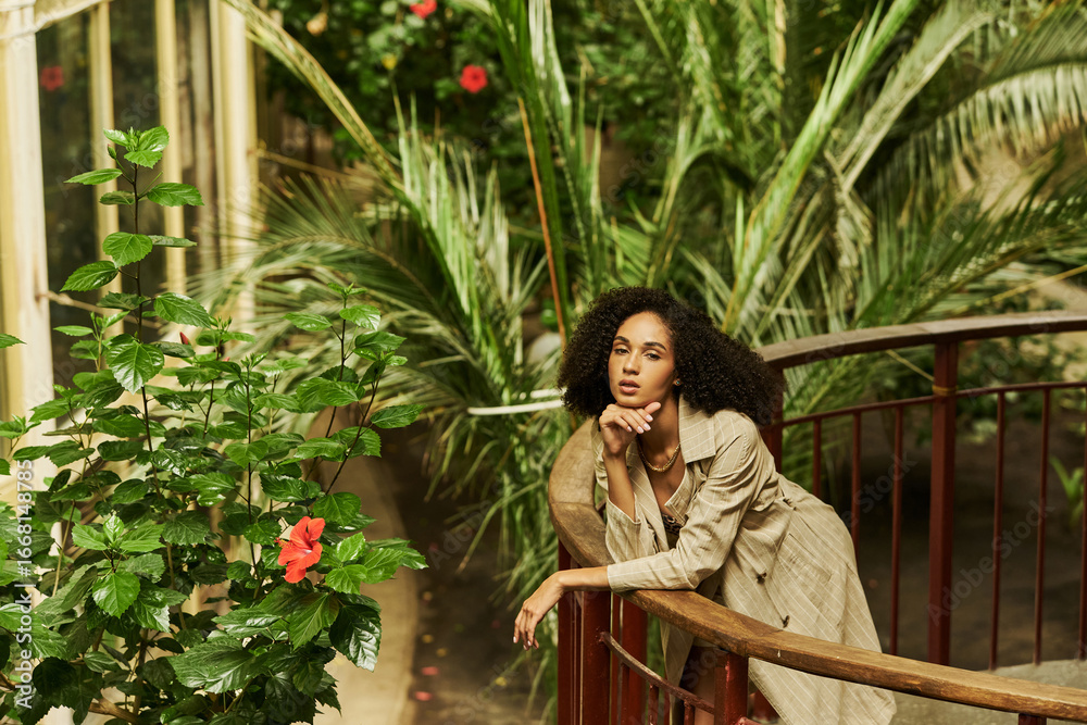 Young woman with curly hair poses in a trendy outfit among plants Stock ...