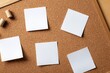 © ffunn - Empty white sticky notes arranged in two rows of three on a cork bulletin board, ideal for planning, reminders, or presentations.