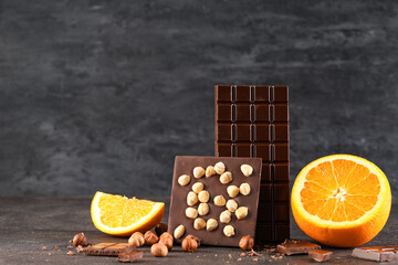 Wall Mural - Sweet chocolate with hazelnuts and orange on dark background