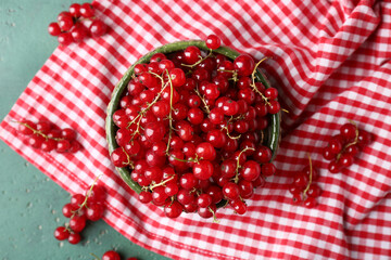 Wall Mural - bowl with fresh red currants on green grunge background, closeup