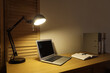 © Pixel-Shot - Blank laptop with glowing lamp and folders on desk in dark office