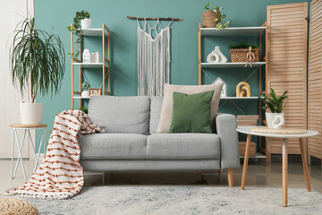Poster - interior of stylish living room with grey sofa, shelf units and plants