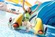 © New Africa - Happy girl on slide at water park. Summer vacation