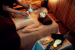 © InfiniteFlow - Hot herbal ball spa massage body treatment, masseur gently compresses herb bag on woman body. Tranquil and serenity of aromatherapy recreation in warm lighting of candles at spa salon. Quiescent