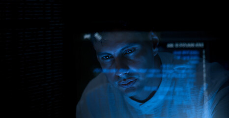 Programmers and coding. Programmer or Developer working in dark room with computer code reflected on their monitor. Cybersecurity software development and hacking idea. show coding digital technology.