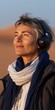 © Andrii Zastrozhnov - Mature caucasian woman enjoying music in desert at sunset with headphones
