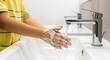 © Shibly - Closeup of a child washing hands with soap and water in a modern bathroom