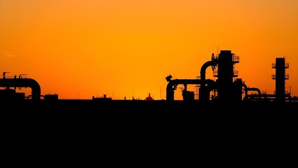 Abstract industrial silhouette against a sunset sky, featuring geometric pipe structures in artistic patterns.