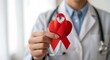 © Jakarta - A red ribbon awareness symbol held by a person in a white coat.