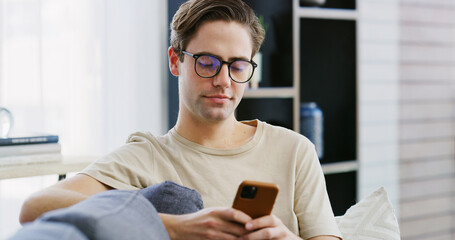 Home, relax and man on couch, cellphone and typing with social media, connection and message to contact. Apartment, mobile user and person on sofa, smartphone and internet with digital app or texting