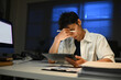© Stella 16 - Business, night and man with stress, headache and burnout with new project, deadline and tired. Male person, employee and consultant with a migraine, pain and overworked and professional working late