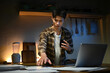 © Stella 16 - Focused man working late at night on laptop in kitchen with coffee