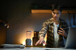 © Stella 16 - Focused man working late at night on laptop in kitchen with coffee