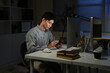 © Stella 16 - Staying late to get it done. Shot of a young businessman using a computer at his desk during a late night at work.