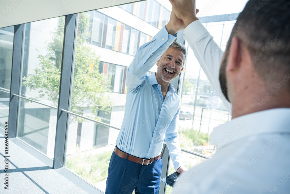 Foto Business colleagues giving high five celebrating success in office ...
