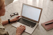 © TrueFrame Collective - High angle rear view shot of unrecognizable mature woman working remotely at home using laptop