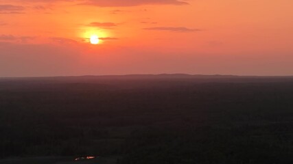 Wall Mural - golden sunset over a vast wilderness landscape with the sun dipping low above the horizon.