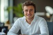 © Riya Kanu - Portrait of a young businessman in a headset, sitting at a desk in the office, smiling and looking confidently at the camera, exuding professionalism and self-assurance in his work, Generative AI