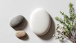 © fahad - Zen Stones Composition: A serene collection of smooth, weathered stones rests beside a sprig of delicate greenery. The arrangement exudes tranquility, inviting a sense of calm and balance.