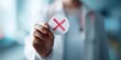 © Studio Nova - The doctor holding a red X sign indicating a wrong diagnosis or rejection
