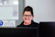 © Austockphoto - Female office staff portrait sitting in front computer screen smiling