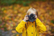 © Igor - Smiling little girl Taking Pictures by DSLR camera.