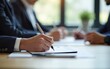 © wu - Closeup of woman hands writing notes during a business meeting with blurred people in the background. High quality