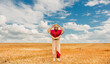 © VISTA by Westend61 - Woman in retro sportswear with headphones and cassette tape in wheat field