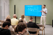 © Anton Gvozdikov - Professional speaker presenting to attentive audience, showcasing information on large screen during conference