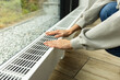 © Point of view - modern radiator for heating in the apartment with power regulators. ideal for those costs of heating and utilities in winter, person regulates the level of heat