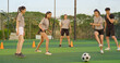 © Raushan_films - Indian young adult gen z coach man blow whistle sport woman lady play casual football outdoor referee male trainer playful female girl wear uniform learn soccer game outside ground