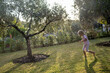 © danr13 - Playful kid splashing through sprinkler water, laughing amid verdant backyard greenery during sunny afternoon