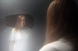 © danr13 - Distressed patient gazing into a grimy mirror in a mental hospital, confronting her troubled reflection amid feelings of despair and loneliness